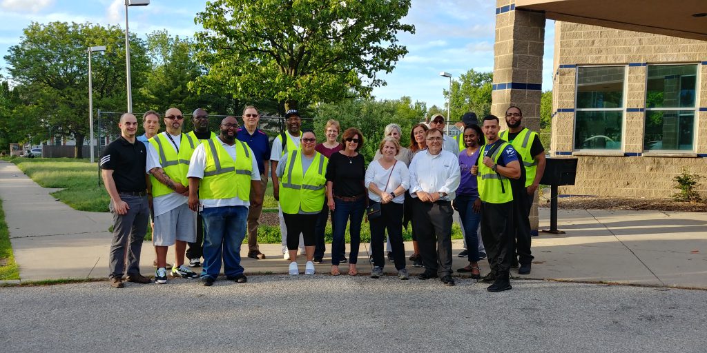 St. Joe staff and board members stand with members of the ten point coalition who patrol their neighborhood to keep their community safe.