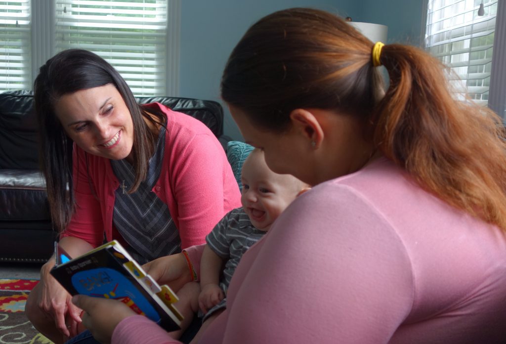 St. Joe grantee, A Mother's Hope Executive Director Stasia Roth, smiles at a resident and her baby